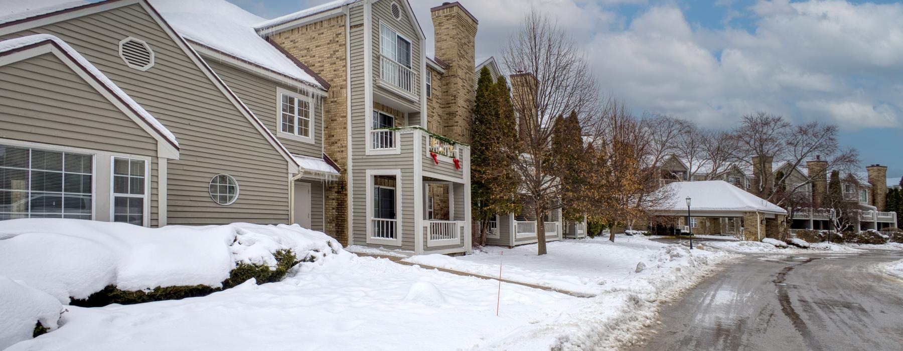 a road with snow on the side and buildings on the side